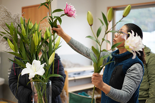 大きな花瓶にユリの花を活けている野村みゆきさんの画像