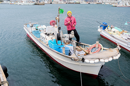 船の上に立っている武井聡さんの引きの画像