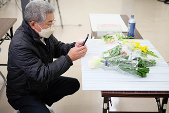 生産者さんがスマホで野菜を撮影している画像