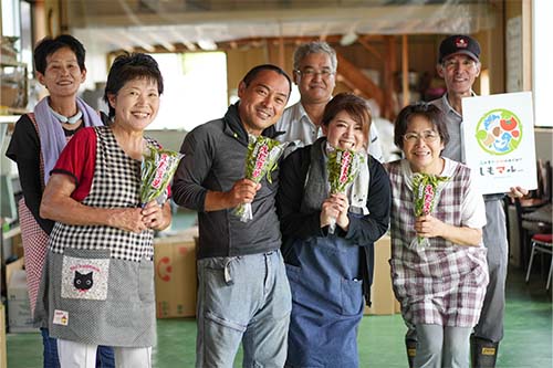 エダマメを手に笑顔の「安岡ひまわりレディース父ちゃん母ちゃんズ」のみなさん