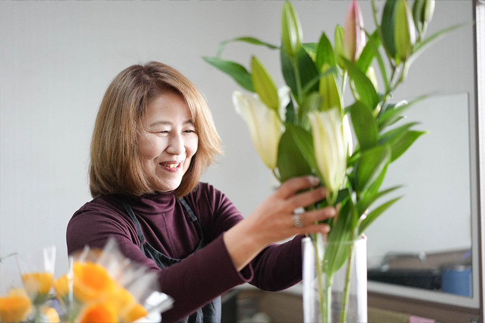 花を活ける山口県花卉園芸農業協同組合の唐渡真由美さん