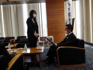安田かおりさんが市長に受賞内容を説明する様子