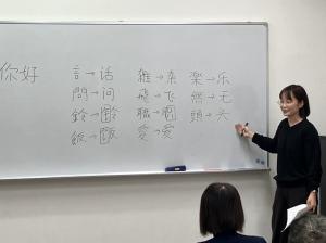 ホワイトボードに漢字を書いて説明する講師