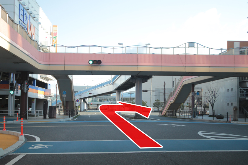 ピンク色の歩道橋をくぐったら右折してくださいの画像