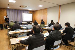 会場に生徒さんがたくさんいて、前で石川先生が話している画像